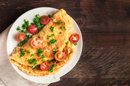 Vegetable omelette with tomatoes and garnishes