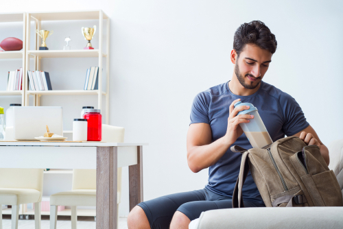 Man putting protein shake in his gym bag