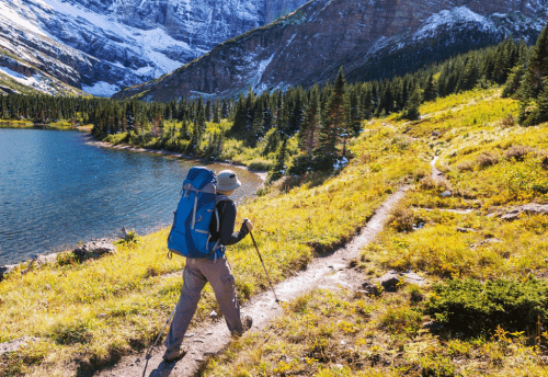 Hiking with poles and pack near a mountain lake