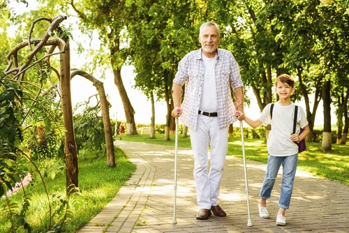 Senior man walking with cane and grandson