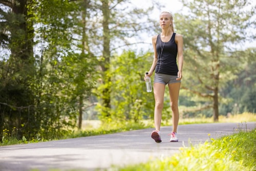 Athletic woman walking for fitness in park
