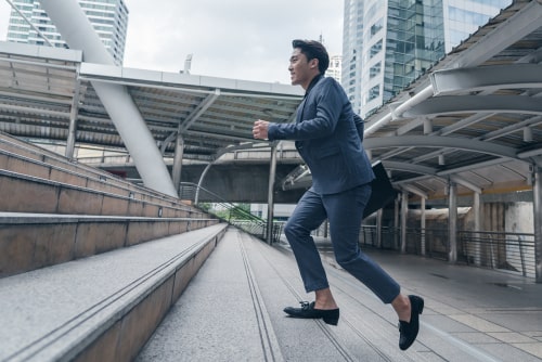 Businessman in dress clothes running up stairs