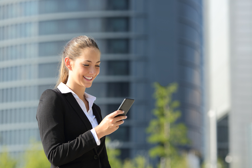 Office worker in suit checking phone outside