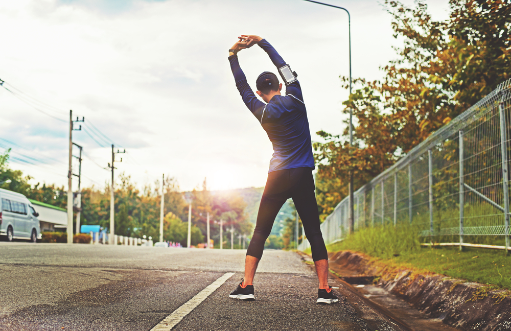 Man stretching near the roadside during a morning walk