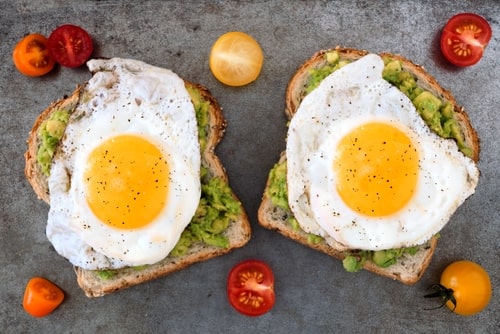 Healthy avocado toast and egg with tomatoes