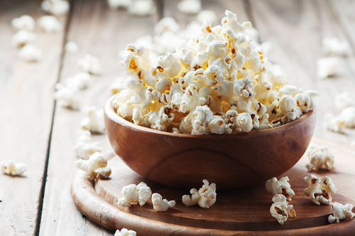 Wooden bowl overflowing with healthy popcorn