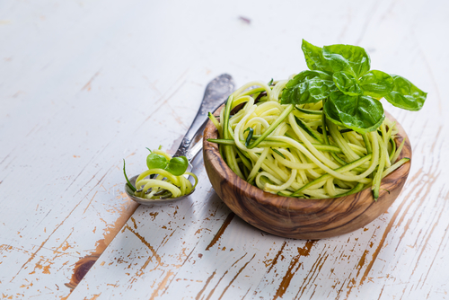 Raw zucchini pasta in a wooden bowl