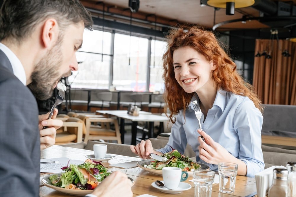 Man and woman eating healthy business lunch
