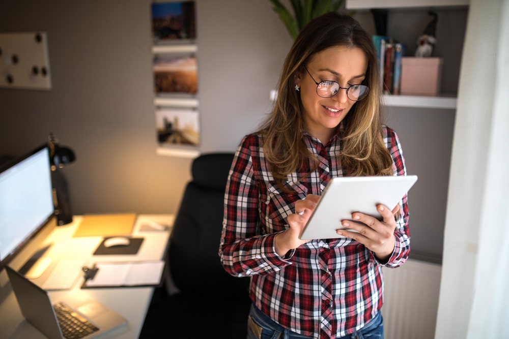 Woman standing up to burn calories working from home