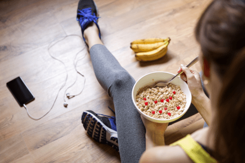 Woman eating a healthy oatmeal breakfast before a walk