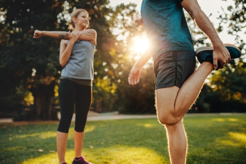Man and woman stretching in park