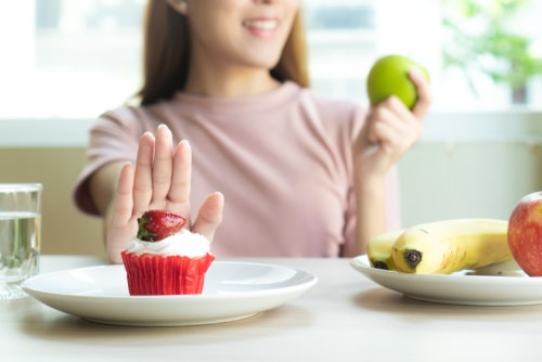woman refusing unhealthy cupcake