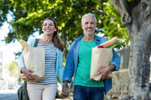 Senior couple walking with groceries
