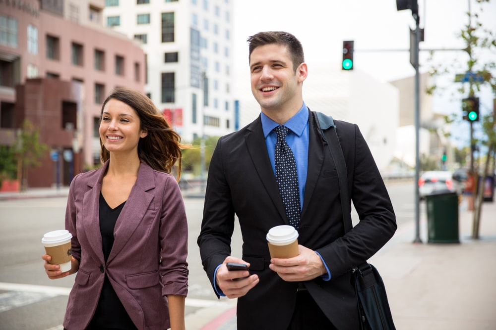 Happy male and female businesspeople walking