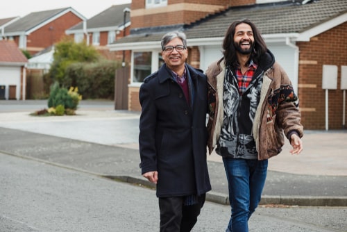 Father and son walking together in a neighborhood