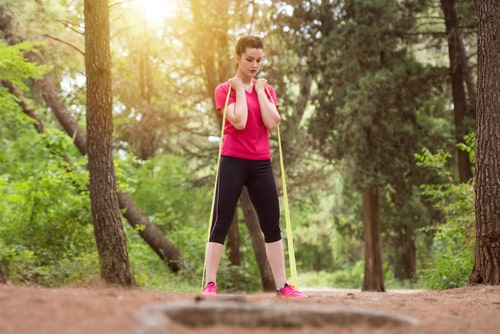 Woman working out in nature with a resistance band