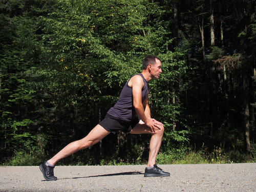 Man doing lunches to stretch after walking