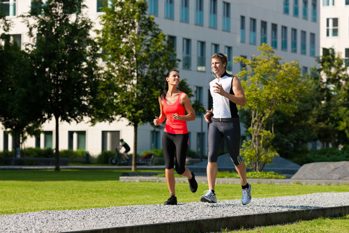 Couple jogging for fitness in a sunny urban park