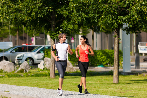 Couple jogging for fitness in a green city park