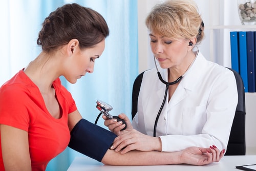 Doctor checking patient's blood pressure