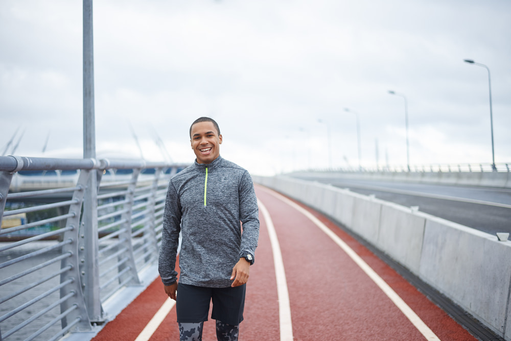 Man walking on a jogging path over a bridge