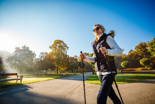 Woman nordic walking in a sunny park