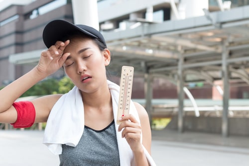 Female walker holding thermometer - hot weather concept