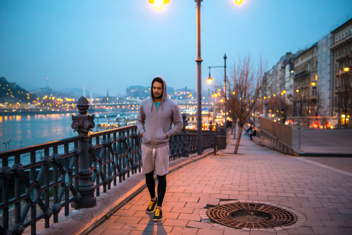Athletic man going for a night walk by the riverside