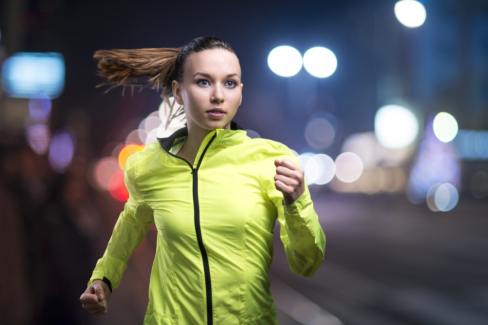 Woman running at night in bright clothing