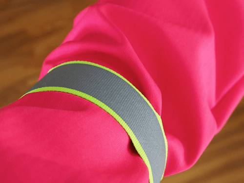 Reflective armband worn over light colored jacket