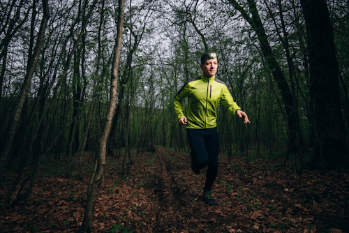 Man jogging in woods with reflective headgear