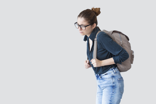 Woman with poor posture due to a heavy backpack