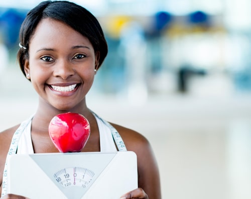Woman holding scale - healthy weight concept