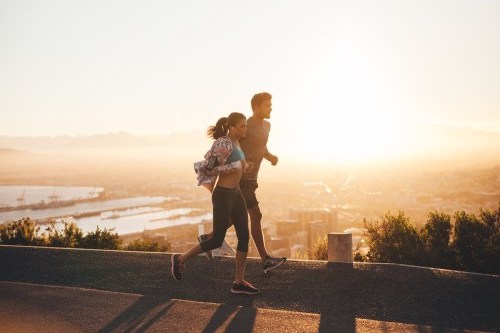 Man and woman fitness walking above a city