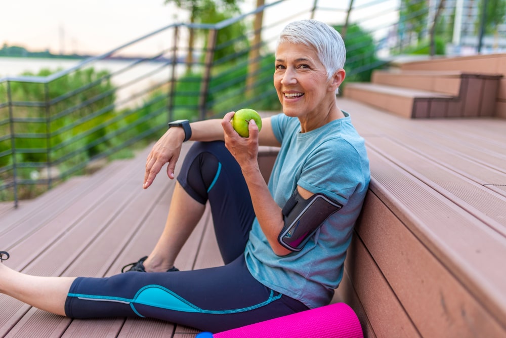 Sporty woman taking a break eating an apple