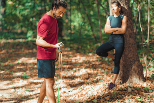 Couple using a resistance band during a walk