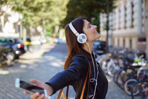 Woman happily listening to music during a walk