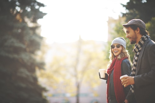 Man and woman walking and drinking coffee