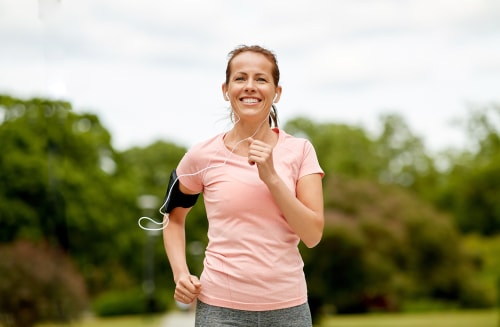 Smiling woman power walking for fitness
