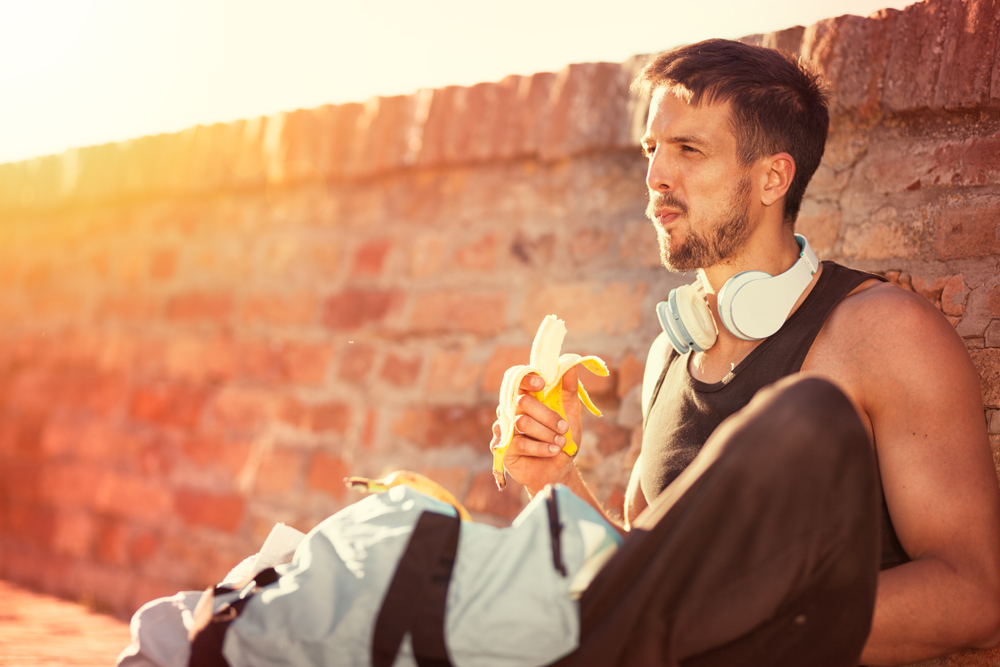 Athlete eating a banana during a walk