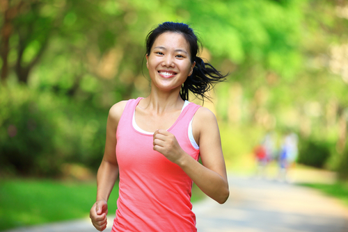 Smiling woman running or walking in the park