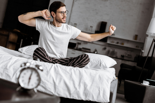 Man waking up with alarm clock