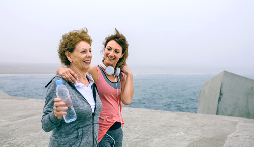 Older and younger woman walking near water