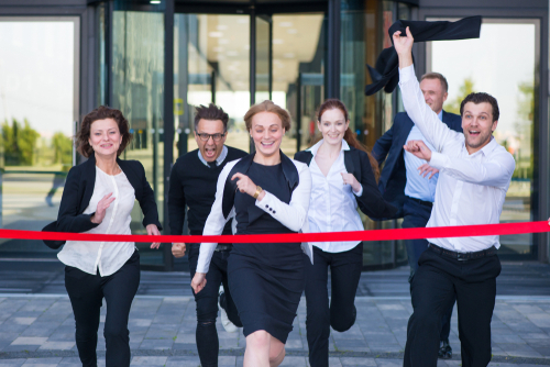 Office workers running and reaching the finish line