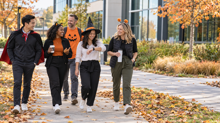 Coworkers in light Halloween costumes walking together outside an office in October