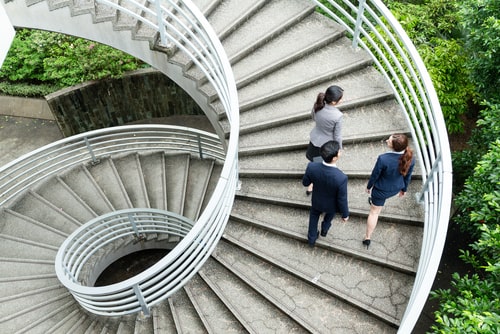 Businesspeople walking up a spiral staircase