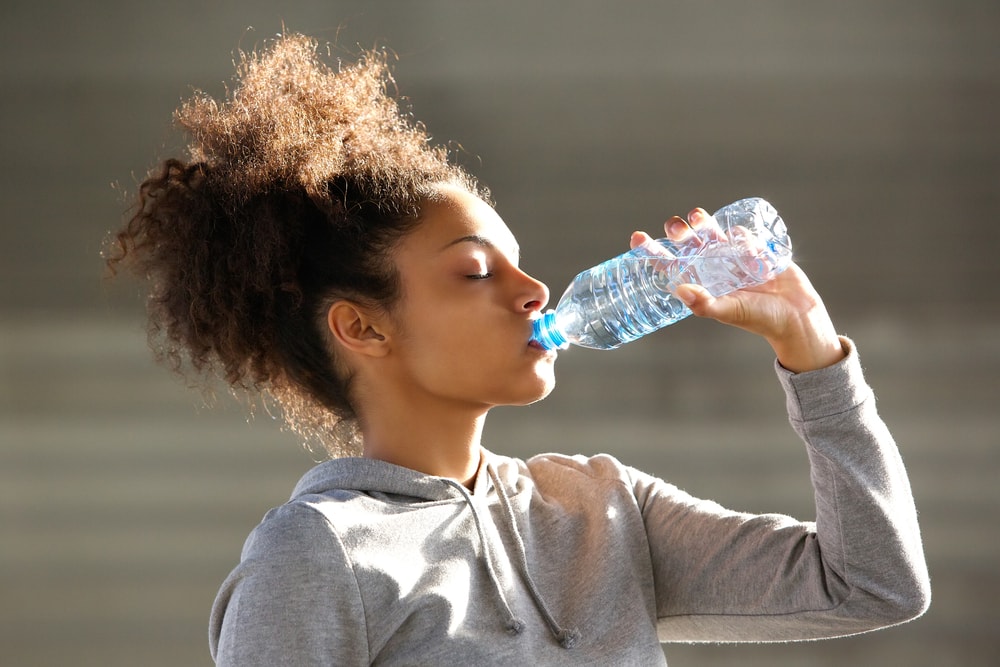 Female athlete drinking bottled water