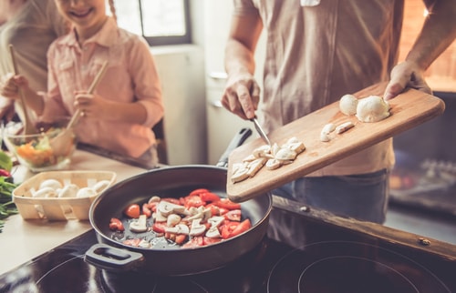 Family cooking a meal at home on the stove