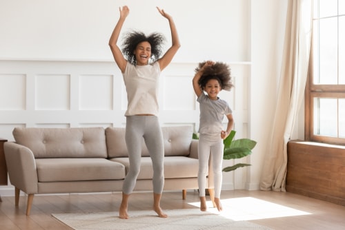 Mom and daughter dancing in living room