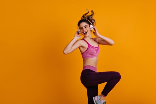 Woman doing dance moves with orange background